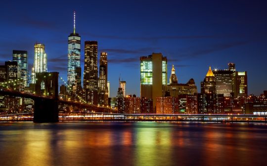 New York City's Brooklyn Bridge and Manhattan skyline illuminated at night