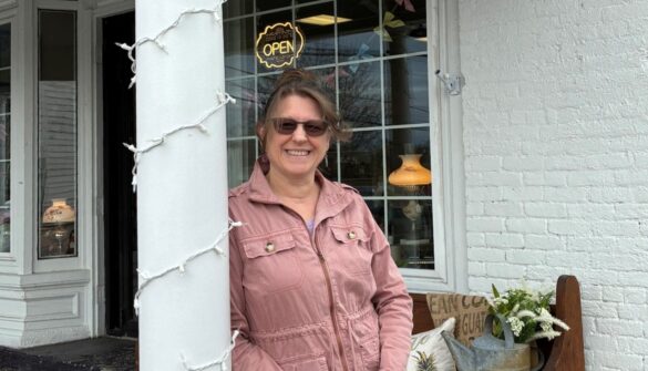 Owner of Dexter Corner Shoppe in front of storefront.
